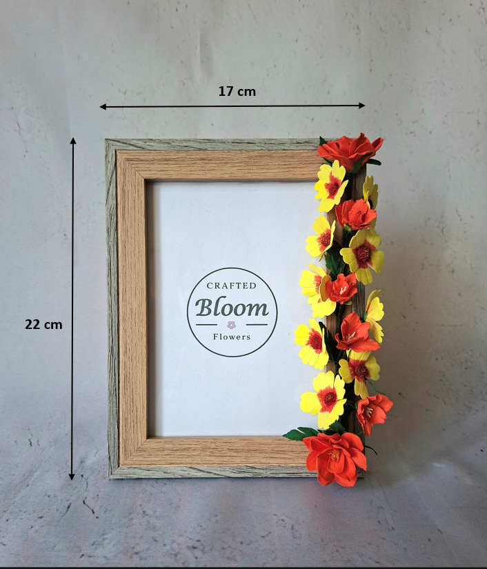 Close-up of handcrafted foamiran flowers in yellow and red decorating a wooden photo frame for home decor