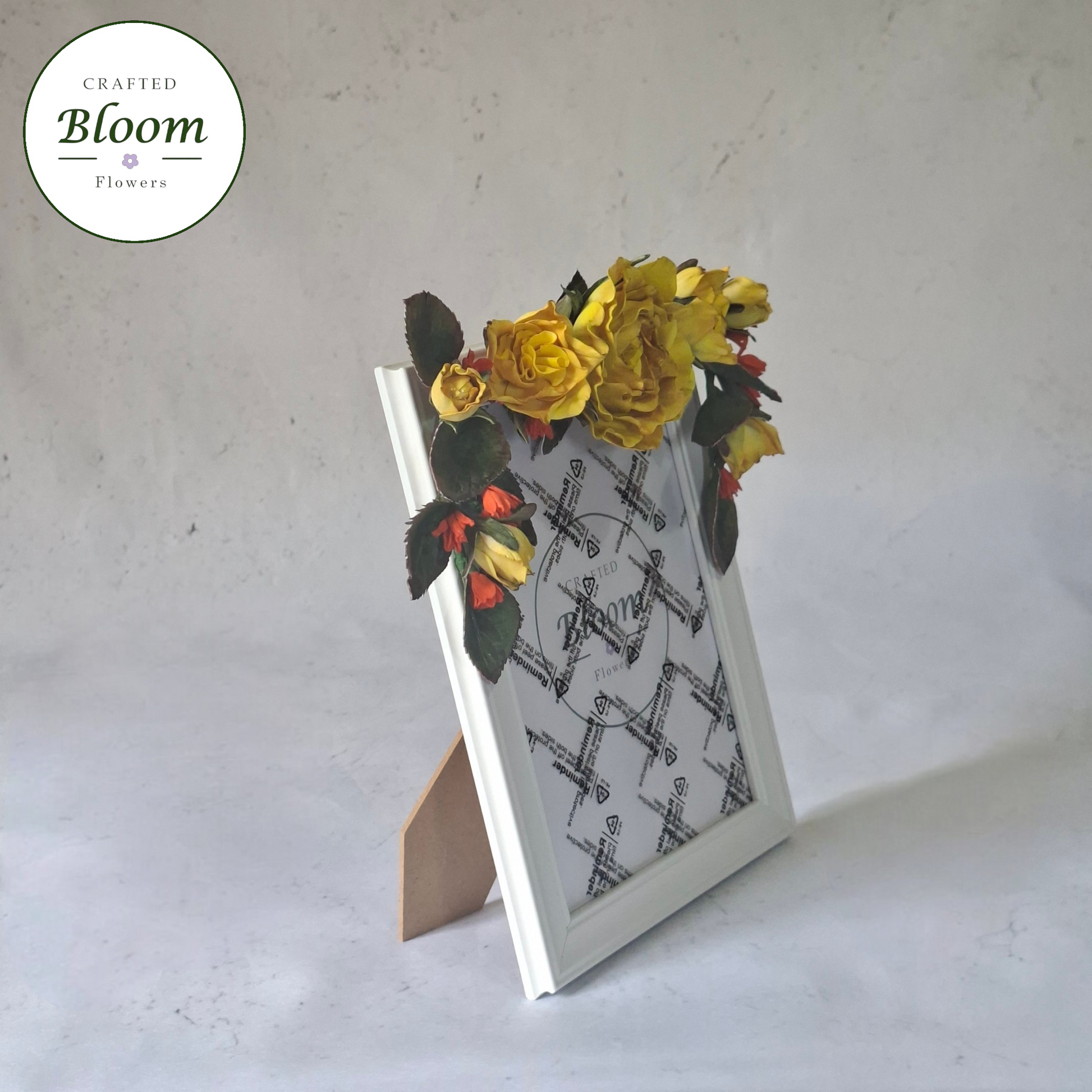 white picture frame decorated with yellow  roses and green foliage on top, Crafted Bloom Flowers